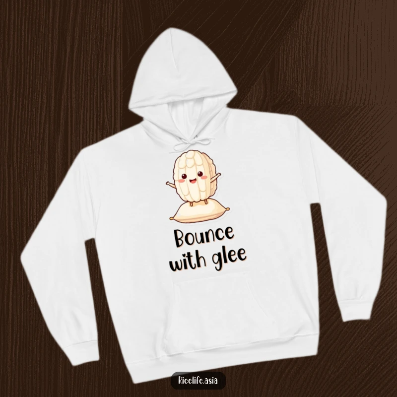 Funny Bouncing Rice Hoodie: A smiling grain of rice character happily bounces on a cushion, offering warmth and funny cheer.